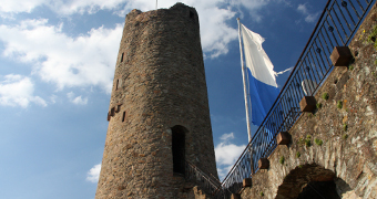 Turm der Burgruine Windeck vor strahlend blauem Himmel mit weißen Wolken