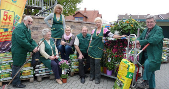 Das Team des Marktes in Mitten von Blumen