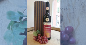 Eine Flasche Spätburgunder Sonderedition mit Weinverpackung im Hintergrund und roten Trauben dekoriert