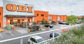 Großes orangefarbenes Gebäude mit großem Parkplatz schön neu angelegt.