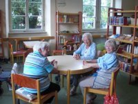 Drei ältere Damen sitzen am Tisch 