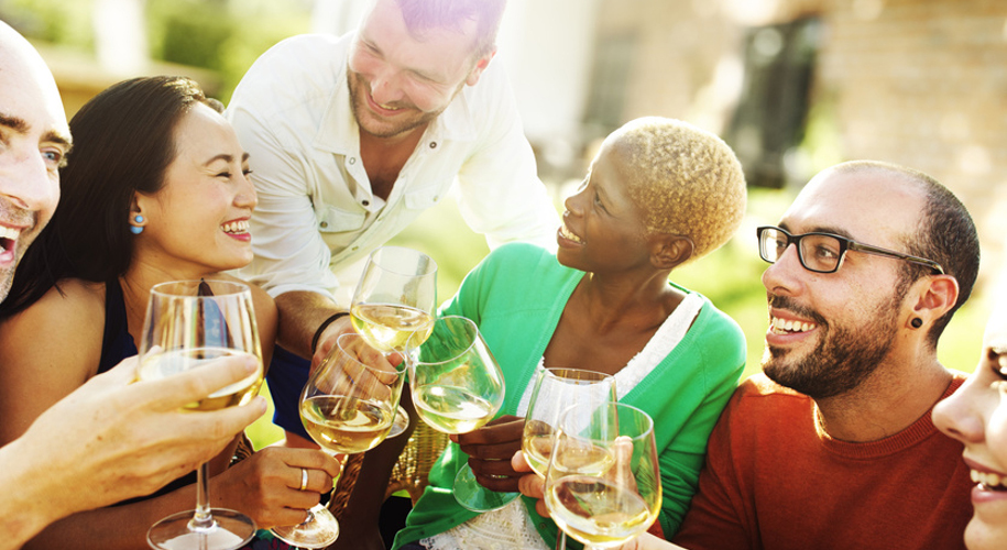 Lachende Menschen beim geselligen Weintrinken