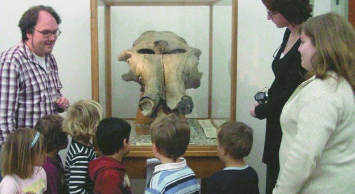 Kinder vor dem Mammutschädel im Museum