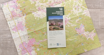 Die Karte mit in grün gehaltenem Cover auf einem Auszug der Karte