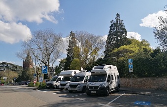 vier Wohnmobile vor dem Schlosspark auf dem Wohnmobilparkplatz
