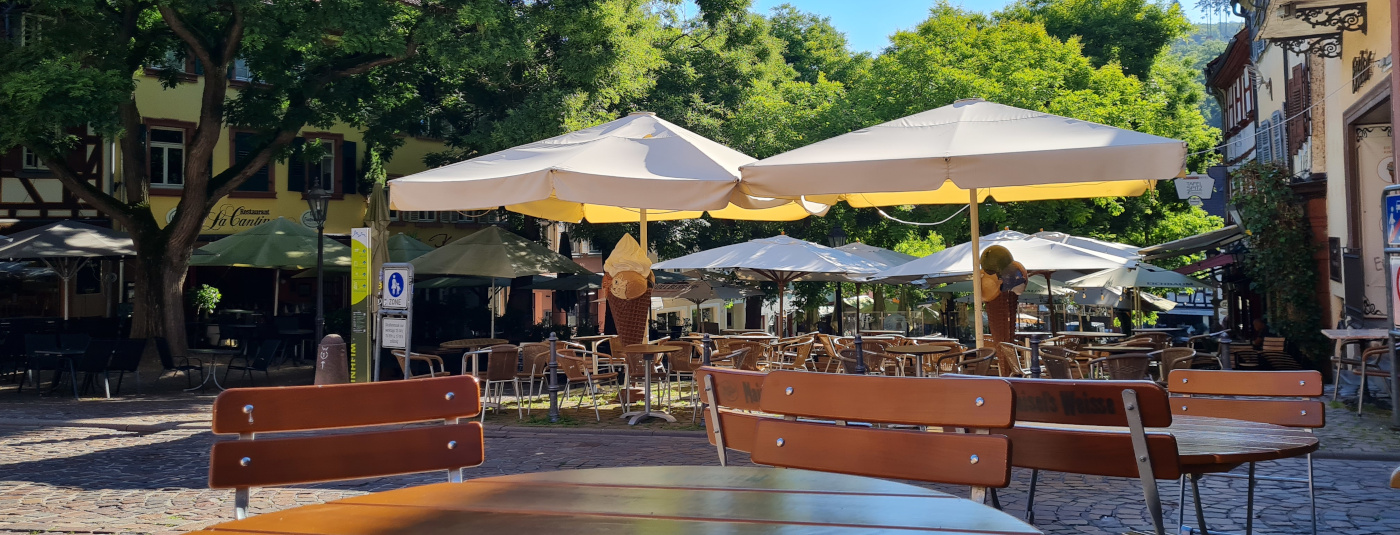 Marktplatz im Sommer - im Vordergrund eine Eisdiele                   